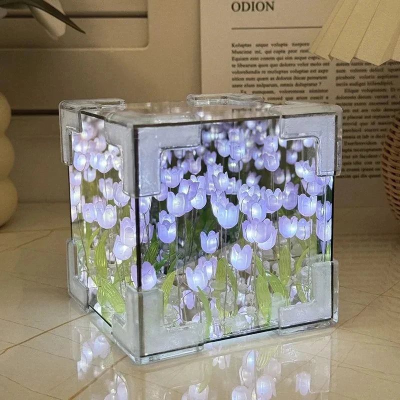 A clear glass cube filled with purple and blue tulip-shaped lights, used as a DIY craft kit or night light.