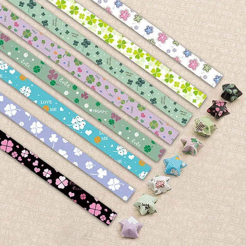 A collection of 27 assorted colored origami star strips for DIY crafting and decor arranged diagonally on a light background.