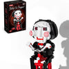 A black and red puppet model of Billy the Puppet from the Jakis horror movie set with a voice recorder.