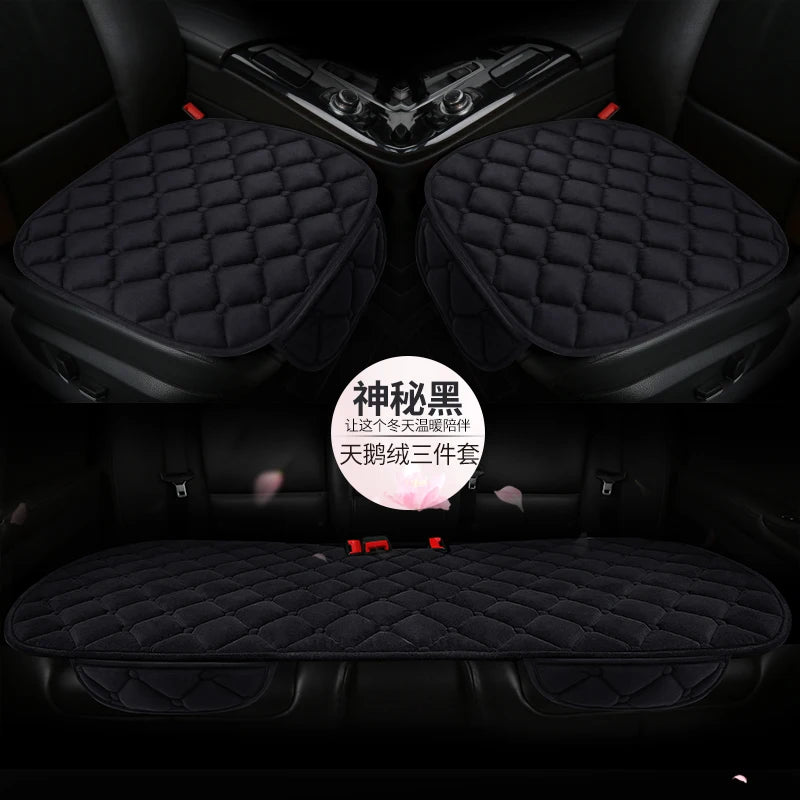 A set of three black quilted car seat cushions for winter warmth shown in a vehicle interior.
