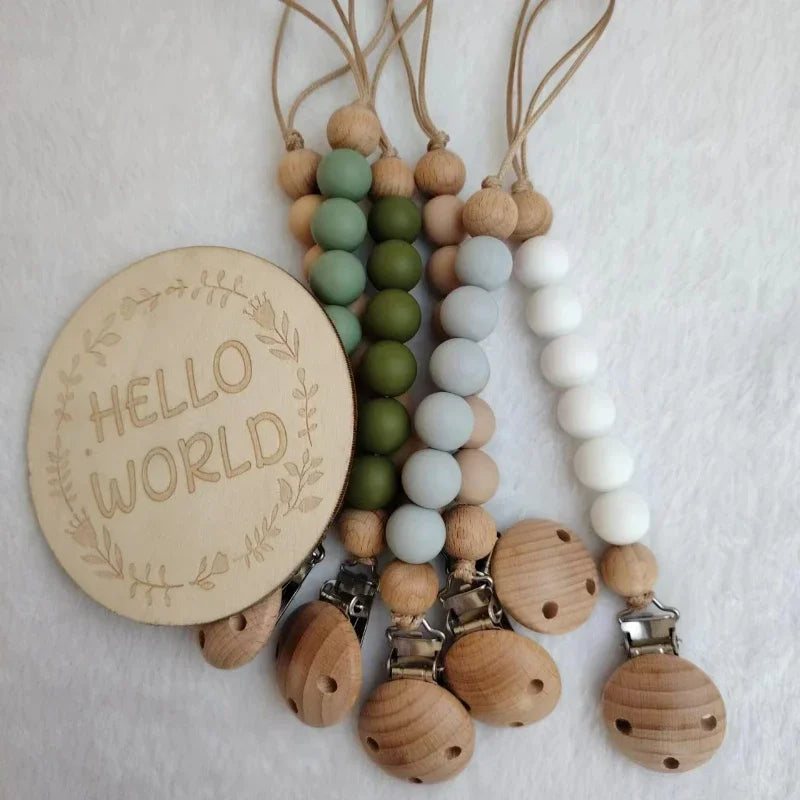 A string of natural wooden beads and silicone clips used as a pacifier or teether.
