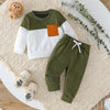 A boy's two-piece sweatshirt set featuring olive green and white contrast panels, laid on a cream textured surface.