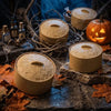 A collection of handcrafted, beige silicone dumpling squishy fidget toys displayed on dark stone and autumn leaves.