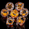 A collection of clear dice shaped like cats in orange and black are displayed on a dark surface.