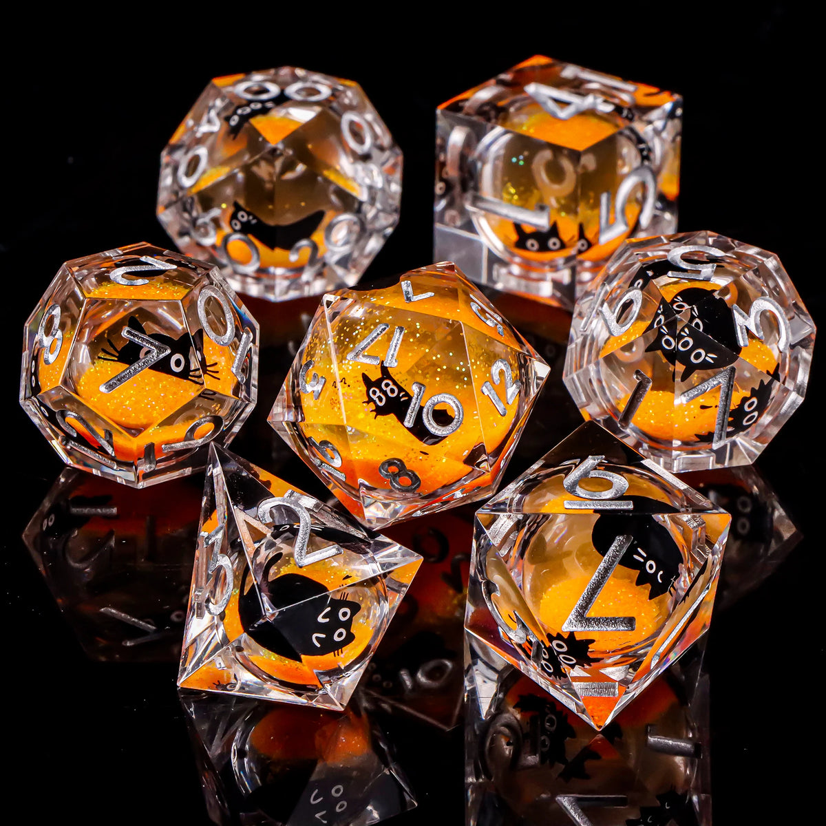 A collection of clear dice shaped like cats in orange and black are displayed on a dark surface.
