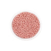 A clear container filled with pink round glass seed beads for jewelry making.