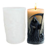 A dark silicone candle mold shaped like a hooded skull with a bat design, featuring a flickering flame.
