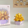 A yellow miniature flower bouquet building block set displayed next to its packaging box.