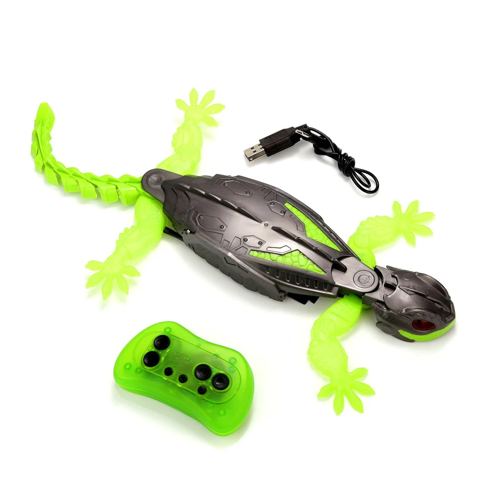 A black lizard robot toy for wall climbing with a green body and a yellow slime accessory and a power cord.