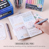 A set of colorful erasable gel pens with an eggshell design lying on a notebook and stationery.