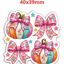 A set of ten pink and multicolored pumpkin flatback resin décor items with bow accents.