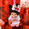 A fluffy black and white Monchhichi plush keychain with pink accents and a red strap.