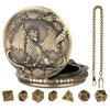 A brass steampunk dragon pocket watch dice case with seven small dice displayed on a wooden surface.
