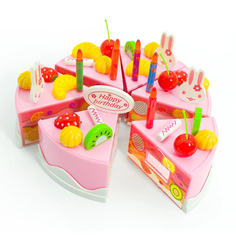 A pink birthday cake with candles and decorations, surrounded by various colorful pretend play items like plastic cutlery and