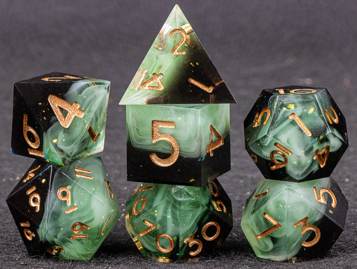 A set of handmade resin polyhedral dice in various shapes and colors resting on a dark surface.