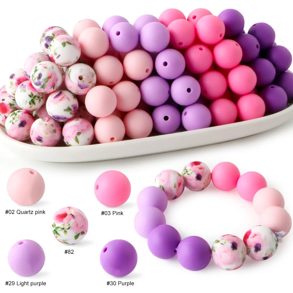 A variety of soft food-grade silicone beads in pink, purple, and white are displayed on a white plate.