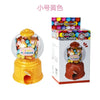 A yellow candy machine dispenser with a clear dome showing colorful candies, next to its packaging.