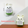 A white crocheted bunny doll with black eyes and a green felt tag featuring an inspirational quote.