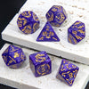 A set of marble dragon pattern polyhedral dice in various colors and shapes resting on a white surface.