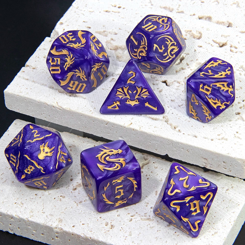 A set of marble dragon pattern polyhedral dice in various colors and shapes resting on a white surface.