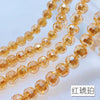 A string of small, round, amber-colored crystal beads with an AB coating.