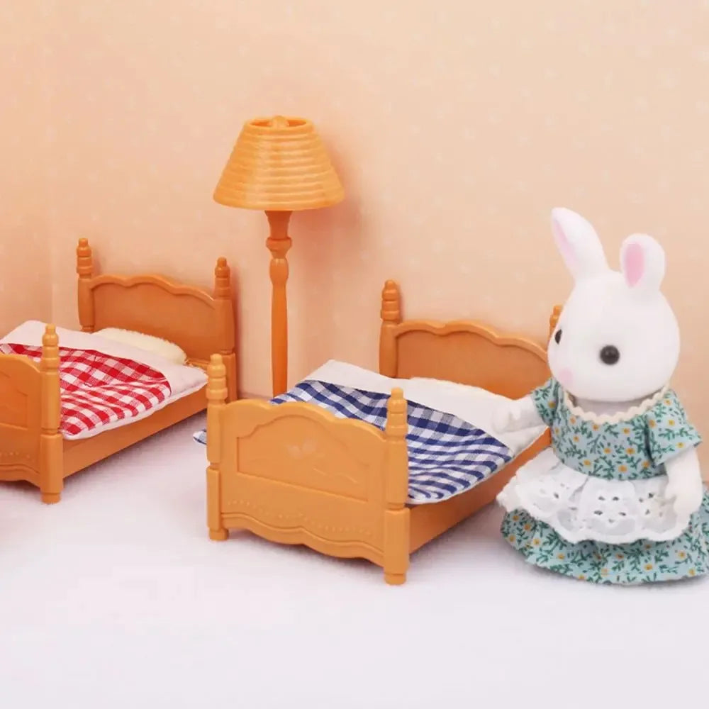 A miniature dollhouse set featuring wooden bed frames and a lamp, with a white rabbit doll dressed in a floral dress.