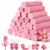 A pile of pink chenille craft pipe cleaners and several small pink flower shapes.