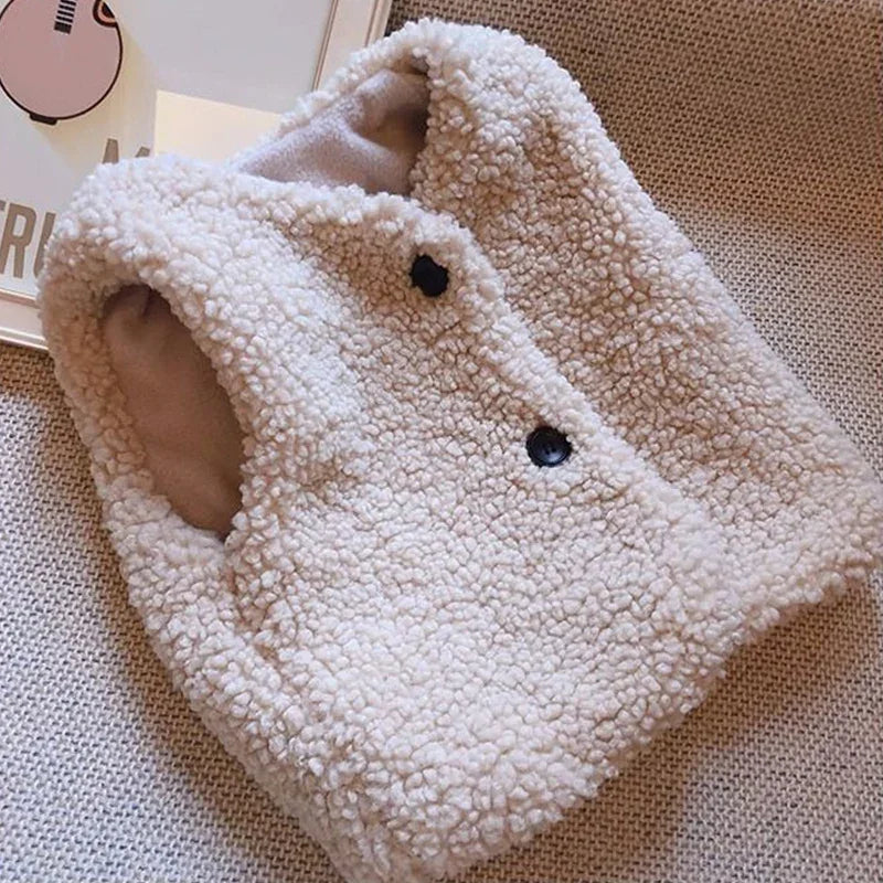 A white, fluffy lamb wool vest with a V-neck and two buttons is displayed on a textured fabric background.