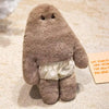A soft, brown monster plush doll with a ruffled skirt is shown on a light background.