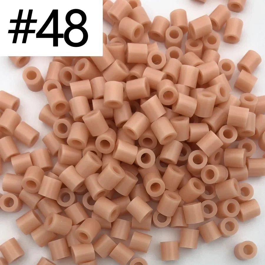 A pile of 1000 small, cylindrical fuse beads in assorted light pink and beige colors for craft projects.
