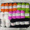 A collection of various colored acrylic wool yarn skeins packaged in a black box for knitting and crochet projects.