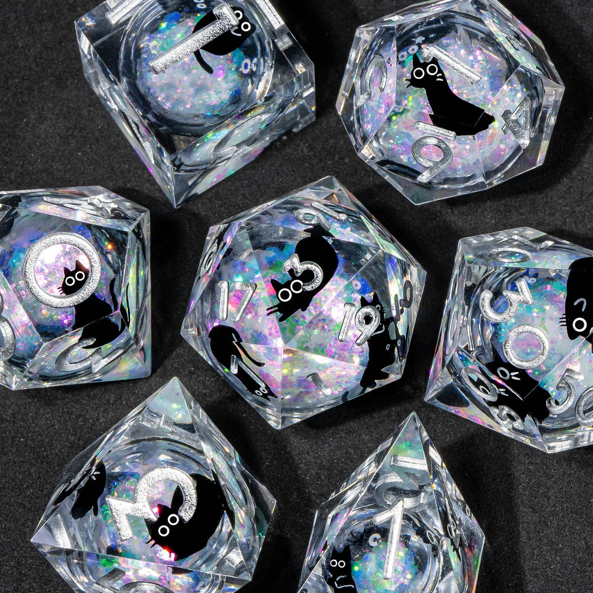 A collection of handmade liquid core resin dice set with sharp edges, featuring various geometric shapes and iridescent color