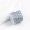 A roll of gray cotton nylon macrame cord for jewelry making and crafts.