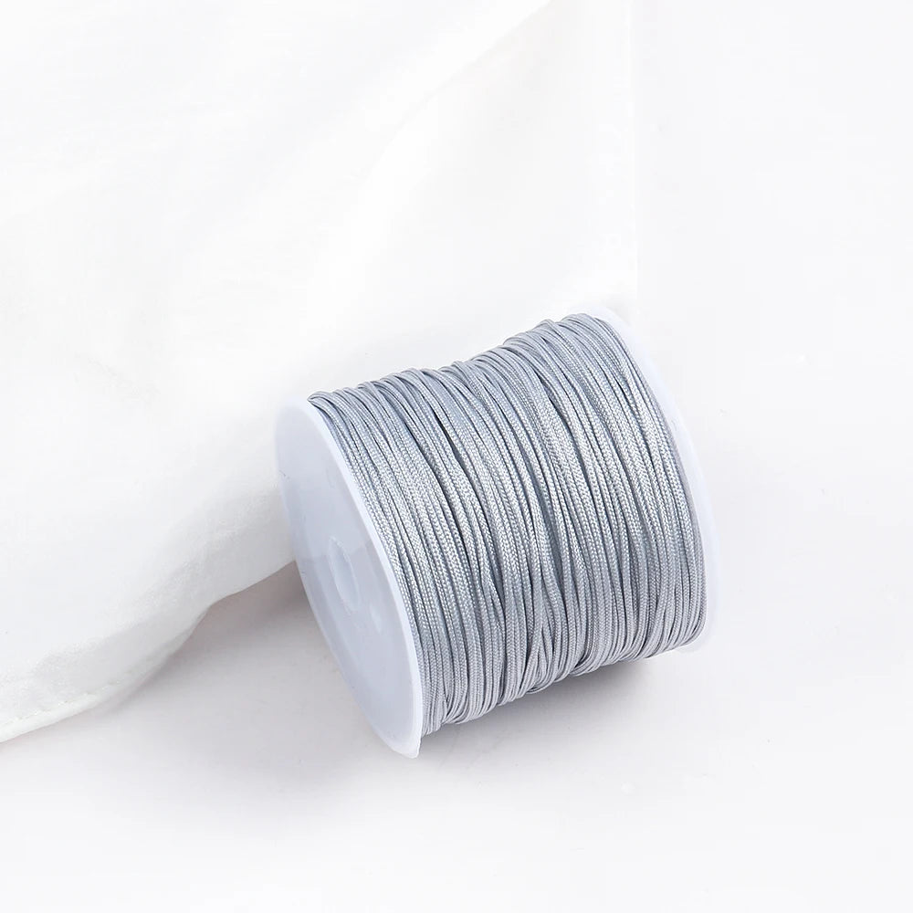 A roll of gray cotton nylon macrame cord for jewelry making and crafts.