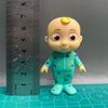 A cute, yellow-skinned cartoon figurine with large eyes wearing a teal school uniform featuring yellow polka dots.