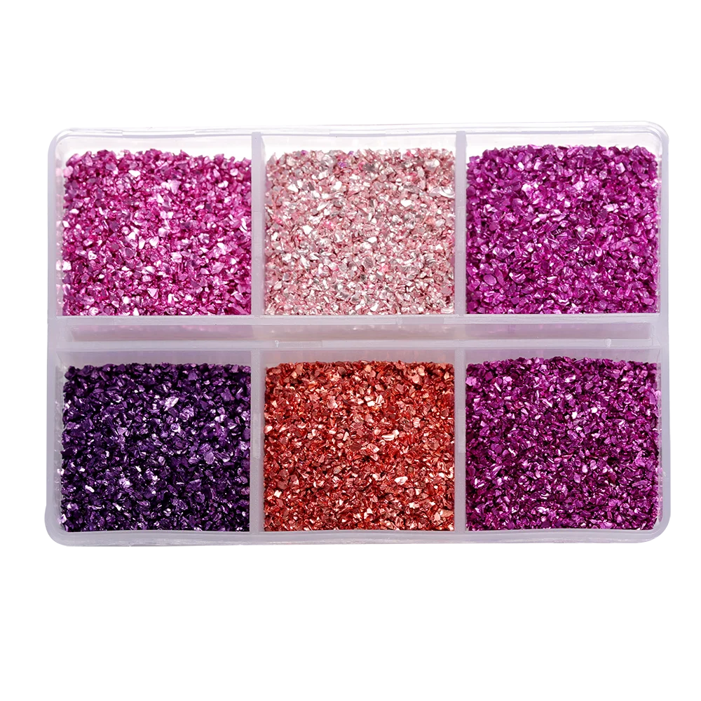 A clear plastic tray filled with five compartments of various crushed glass stones in shades of purple, pink, and red.