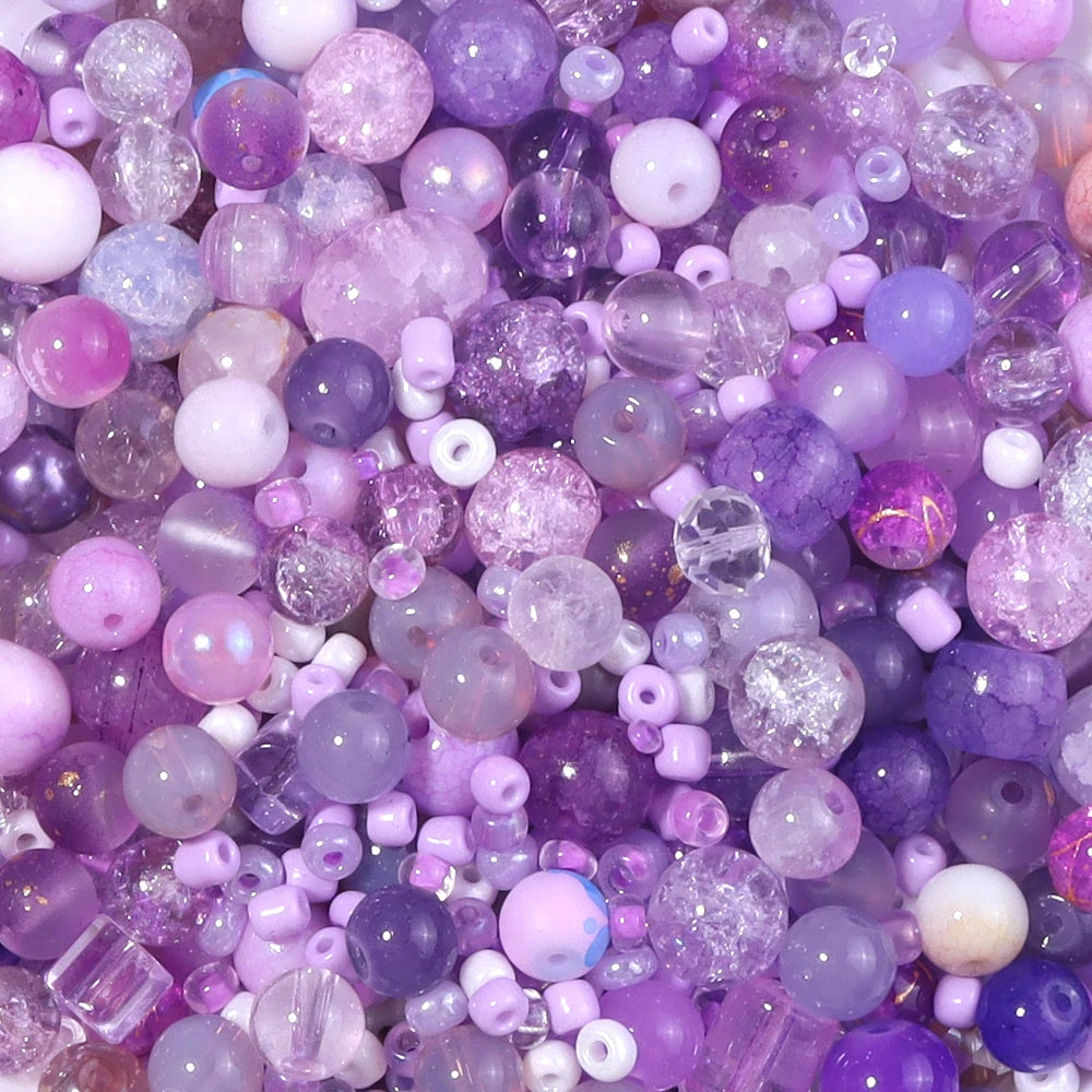 A close-up view of a vibrant mix of purple and pink glass beads for DIY jewelry making