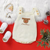A cream knit baby romper with a brown Santa embroidery and wooden buttons, displayed on a red background with white faux fur.