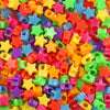 A close-up of a pile of multicolor pony beads in various shapes and colors for jewelry making and crafts.