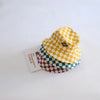 A stack of yellow and purple checkerboard bucket hats made of soft cotton.