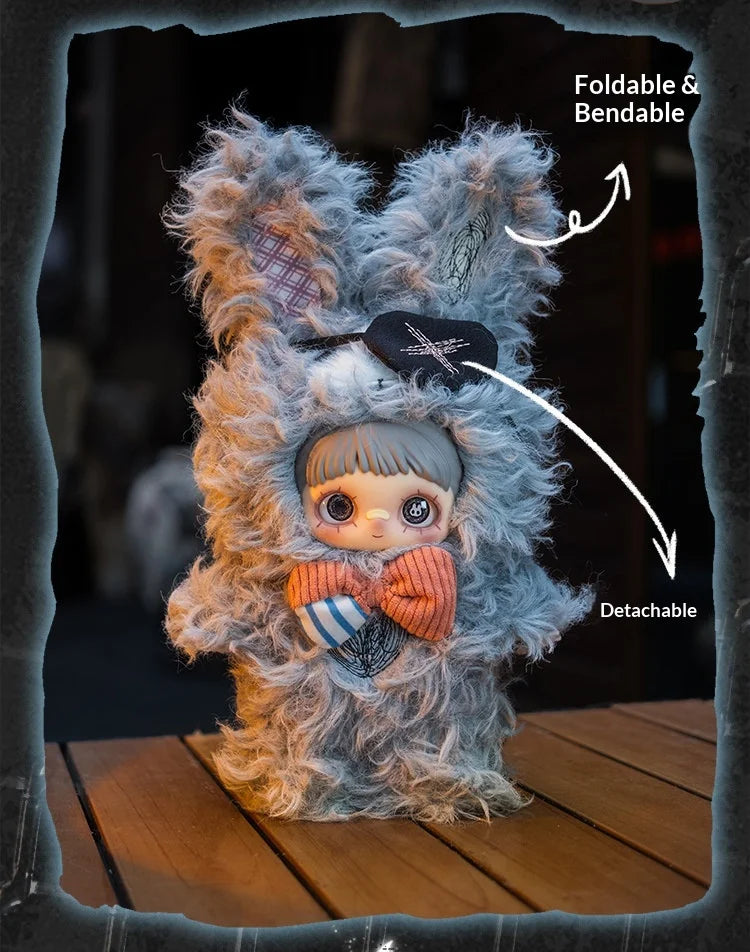 A fluffy gray plush doll with a face, orange bow, and detachable features, shown against a dark background.