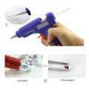 A hand uses a purple glue gun to attach glass crystal flatback rhinestones to a nail or craft item.