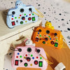 Three colorful Montessori busy boards with LED light switches for toddlers displayed on a wooden surface.