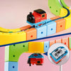 A red magnetic train engine on a yellow track with colorful plastic pieces for kids