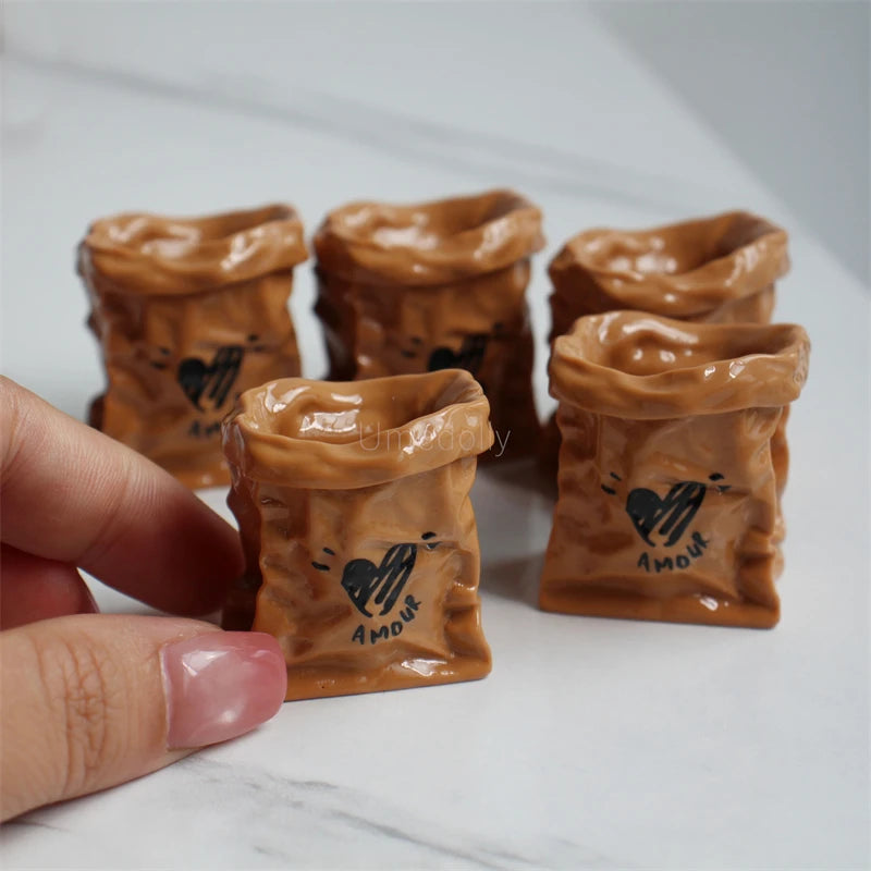 A set of miniature dollhouse baguette baskets made of brown clay, some featuring a small heart design.