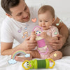 Un bébé joue avec un accordéon musical vert, tenu par un homme, entouré de notes et d'un arc-en-ciel.
