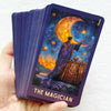 A tarot card depicting The Magician with a purple cloak and golden light against a starry night sky.