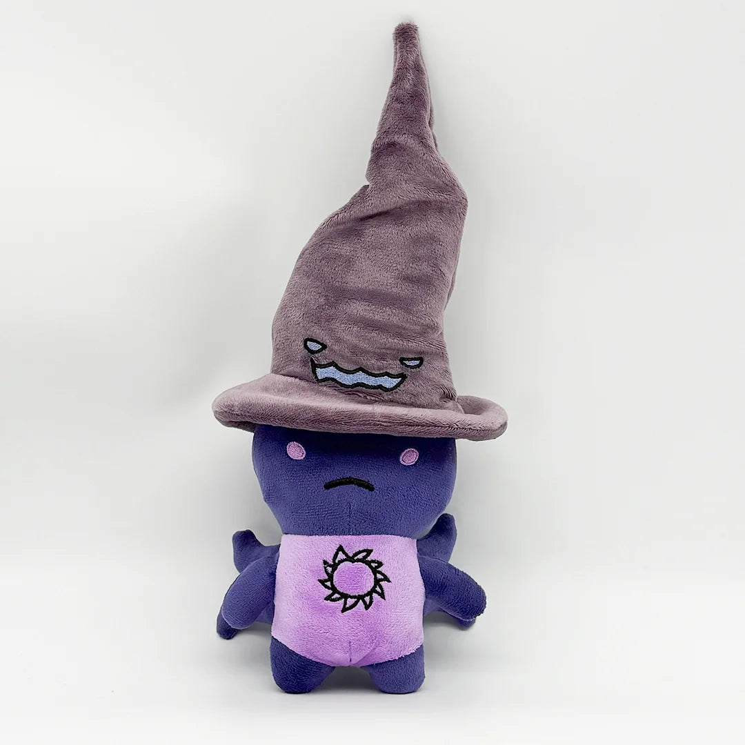 A purple plush rabbit toy wearing a witch hat and a purple shirt with a sun design.