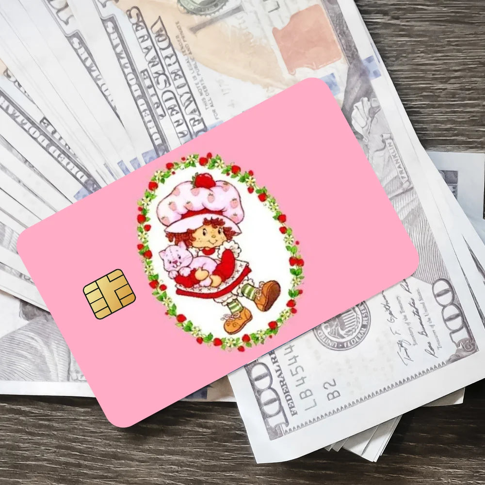 Pink card with a cute strawberry and shortcake illustration on a background of money.