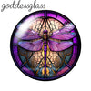 A round glass cabochon featuring a purple dragonfly design with intricate details.